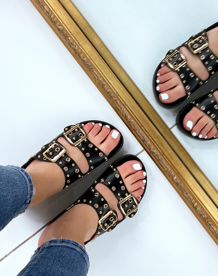 Mules plates noires à lanières ajustables et clous dorés