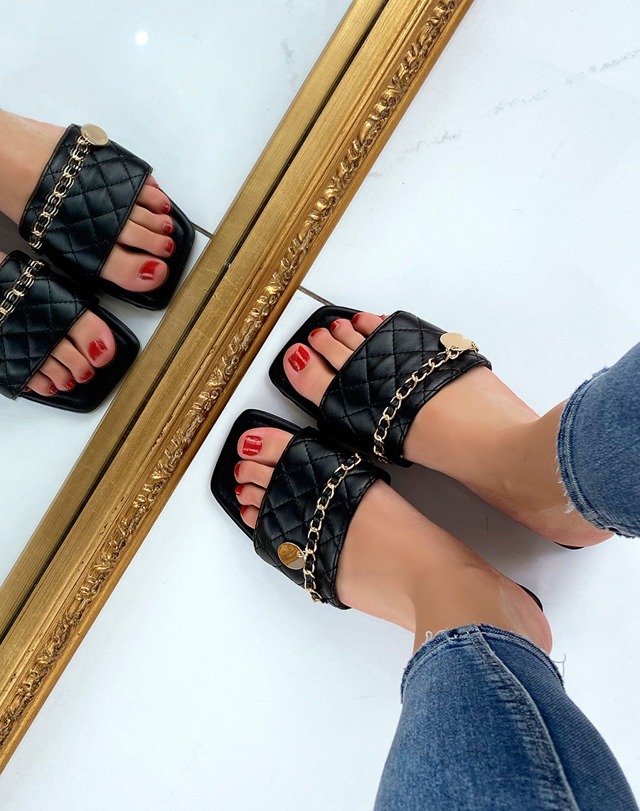 Mules plates noires matelassées à fine chaine dorée et bout carré