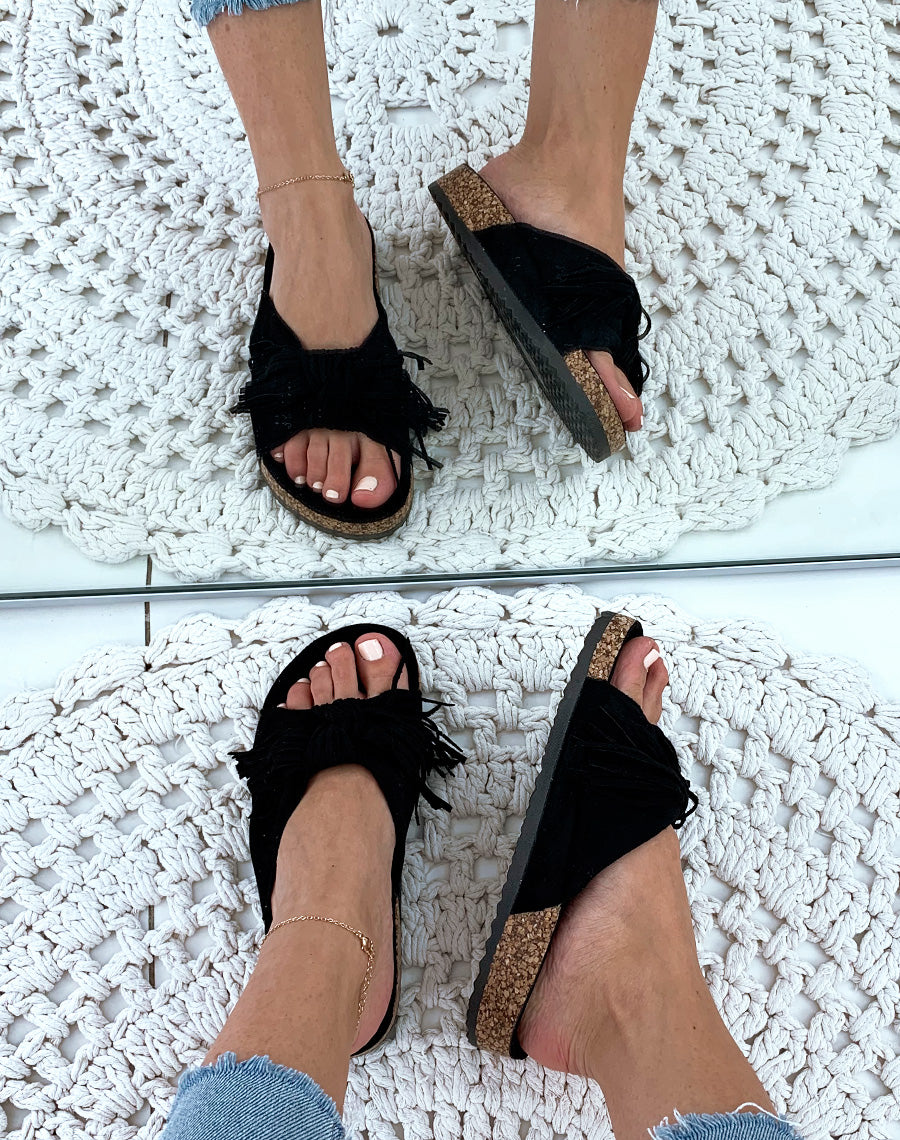 Mules une suédine noires à larges brides en nœud et à franges