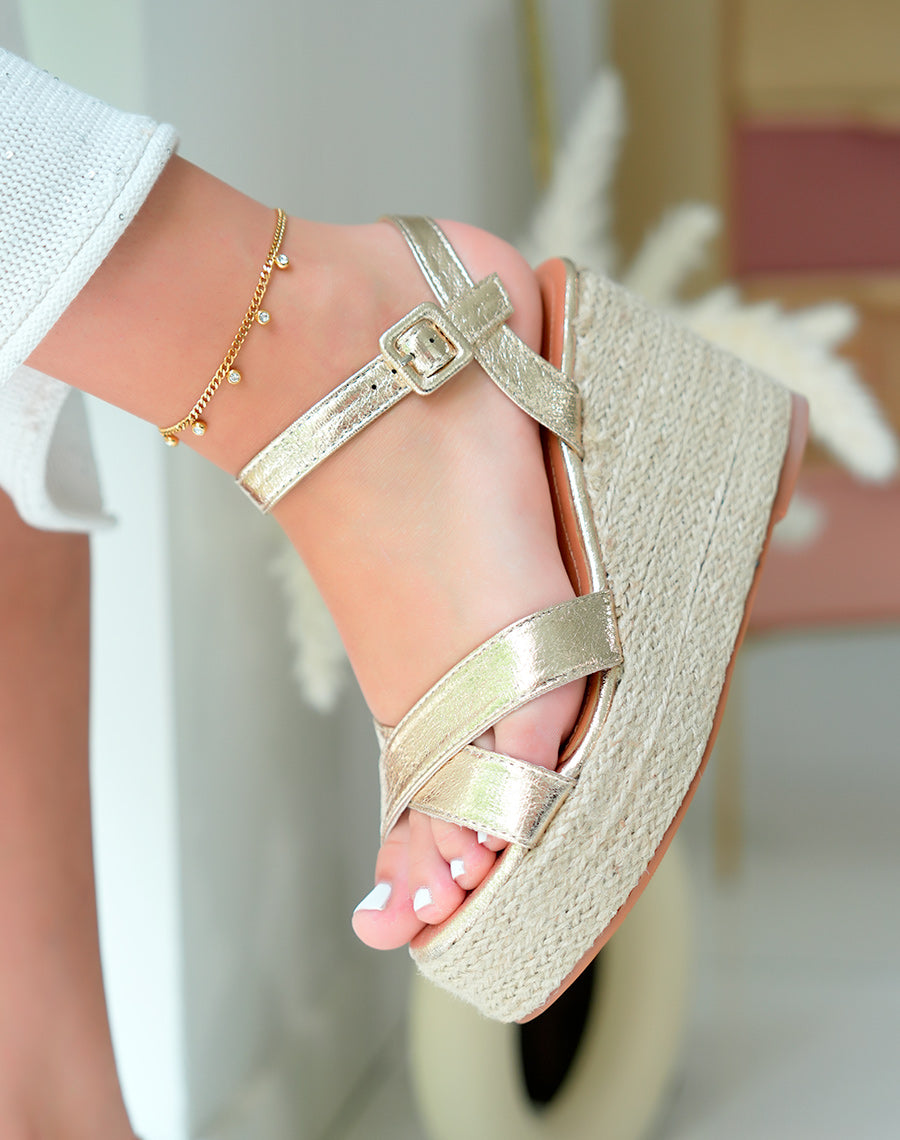 Golden female sandals with intertwined bridle and elegant wedge heel